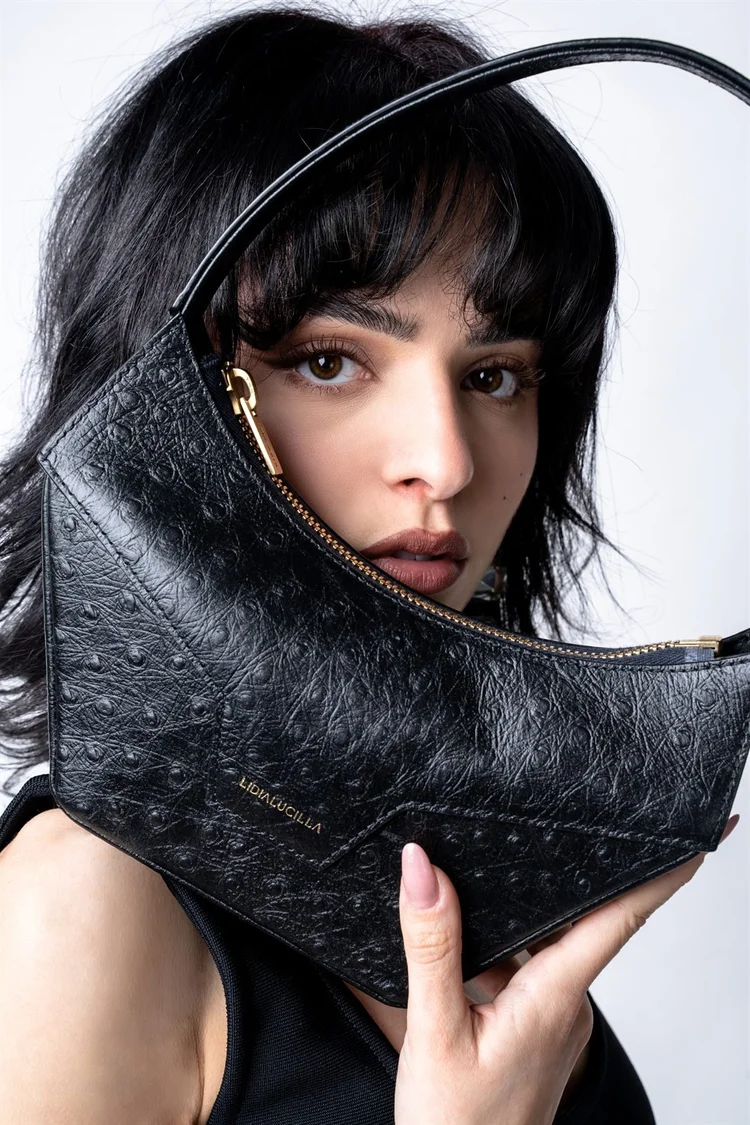 Shooting per un brand di borse: modella con borsa nera intorno al viso