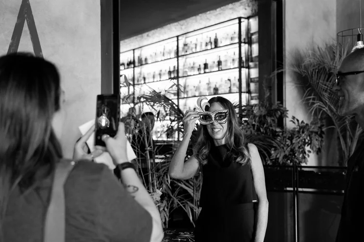 Festa in bianco e nero: invitati che si scattano foto al bancone di un bar, foto di Matilde Rindi, fotografa a Prato