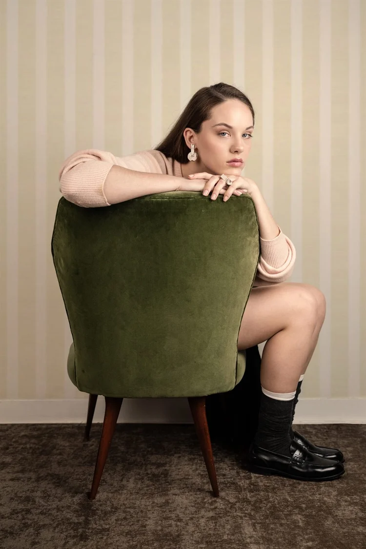 Servizio editoriale: ragazza seduta su una poltrona di velluto verde, foto di Matilde Rindi, fotografa a Prato