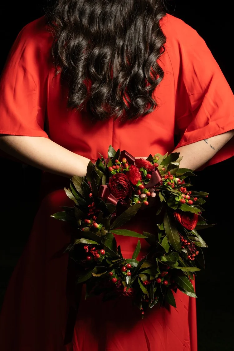 Laurea: corona d'alloro tenuta dietro la schiena, abito rosso, foto di Matilde Rindi, fotografa a Prato
