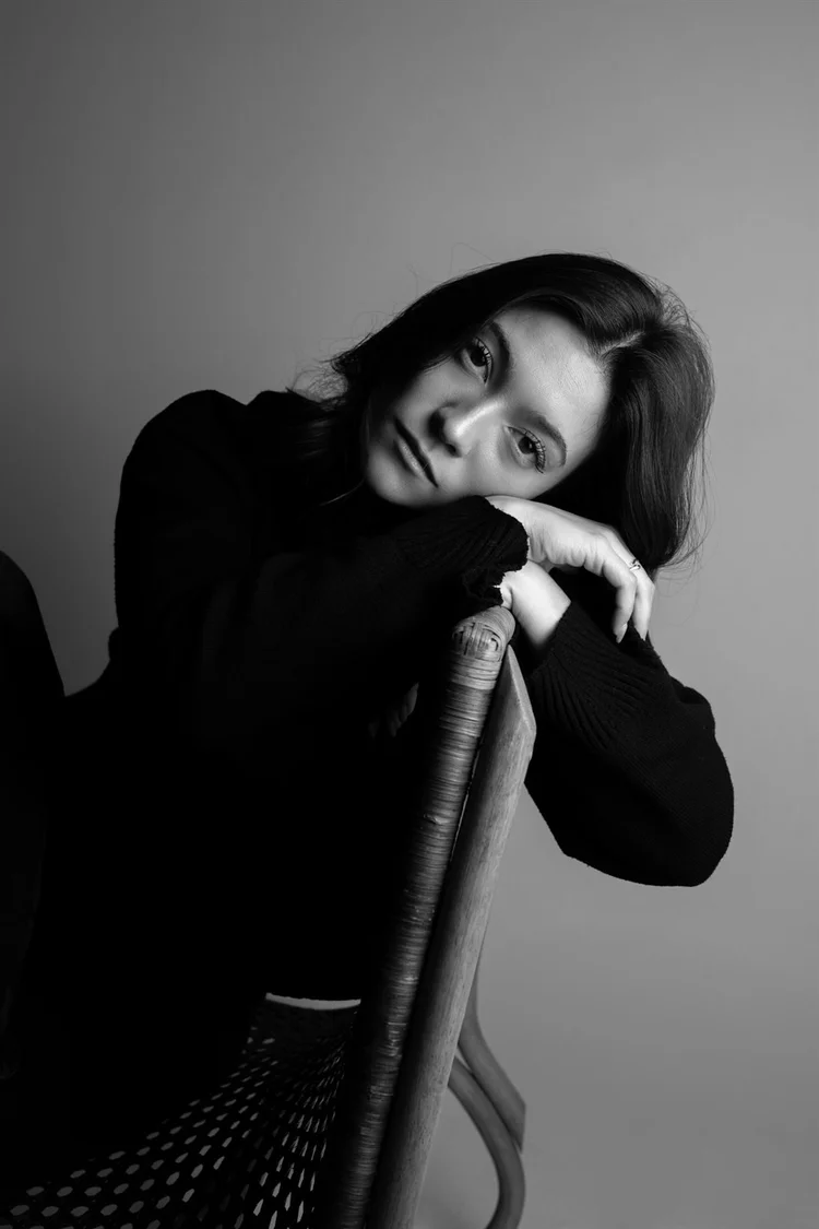 Book attrice in bianco e nero appoggiata allo schienale di una sedia, foto di Matilde Rindi, fotografa a Prato