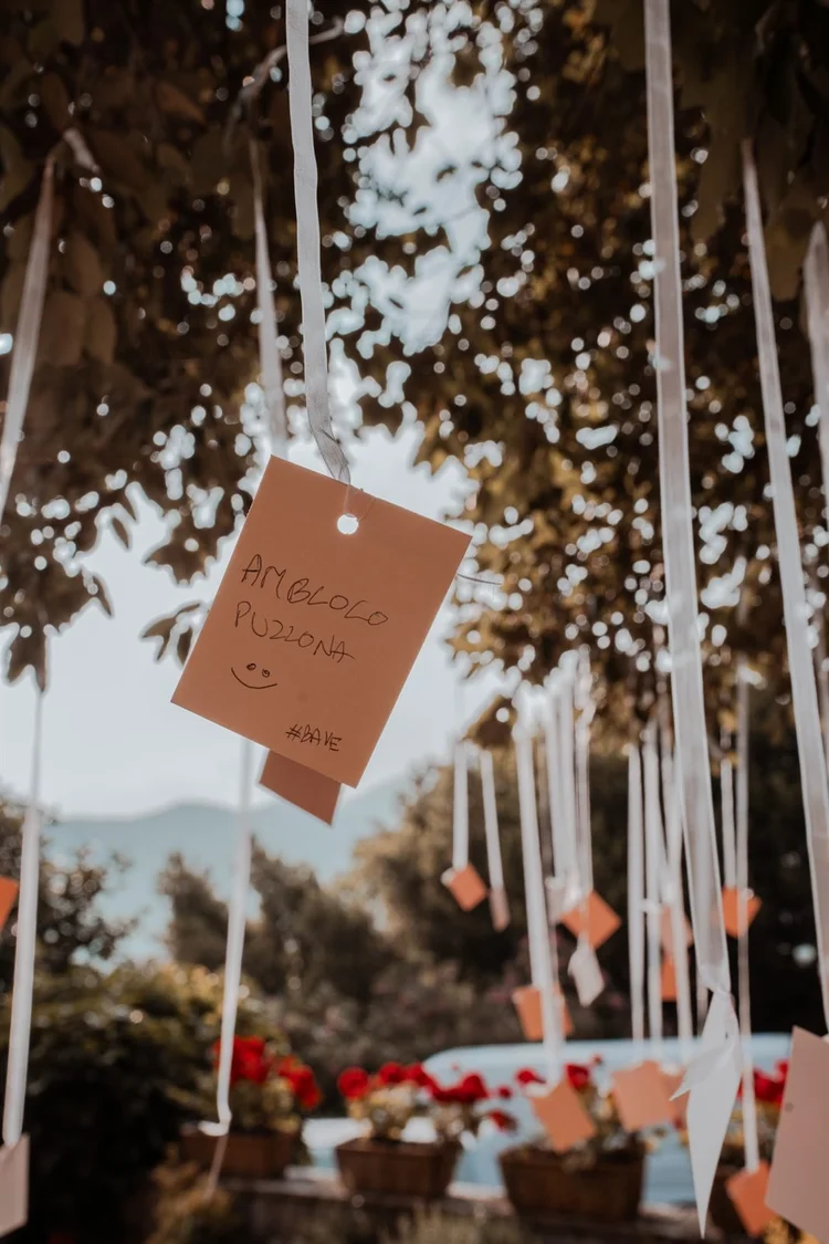 Allestimento di una festa all'aperto con nastri e cartellini appesi agli alberi, foto di Matilde Rindi, fotografa a Prato
