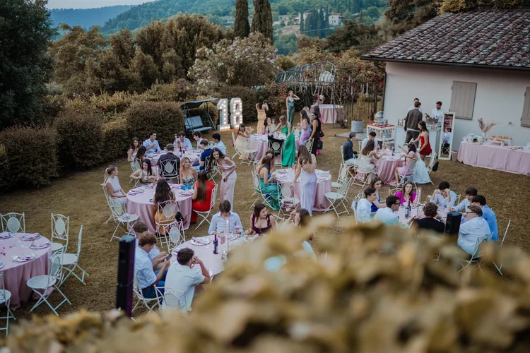 Festa all'aperto in villa con gli invitati ai tavoli, foto di Matilde Rindi, fotografa a Prato