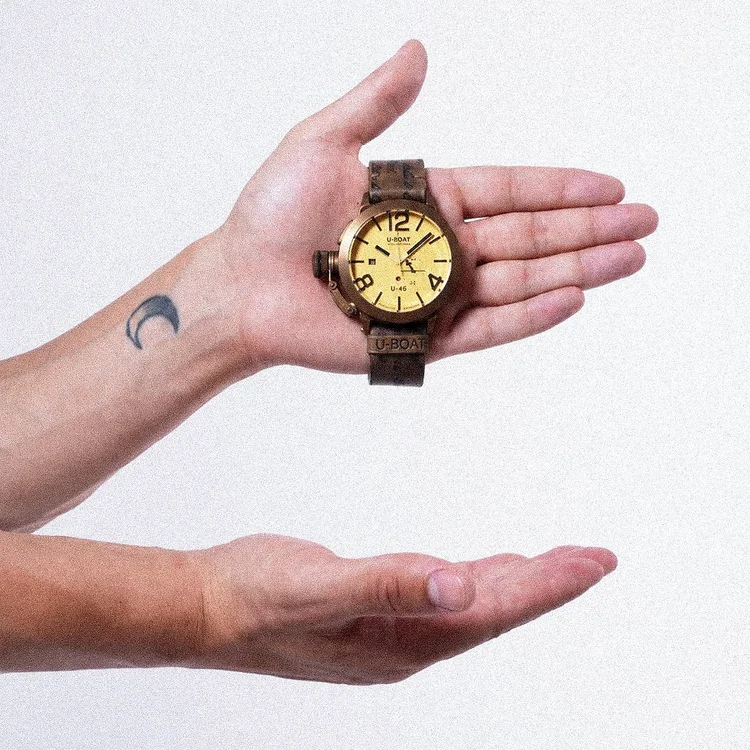 Foto prodotto per orologi: orologio in bronzo tra le mani, foto di Matilde Rindi