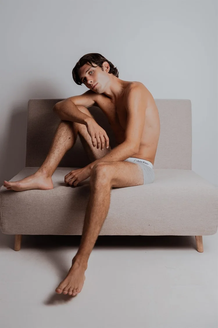 Book per modelli: ragazzo a figura intera seduto su un divano, foto di Matilde Rindi, fotografa a Prato