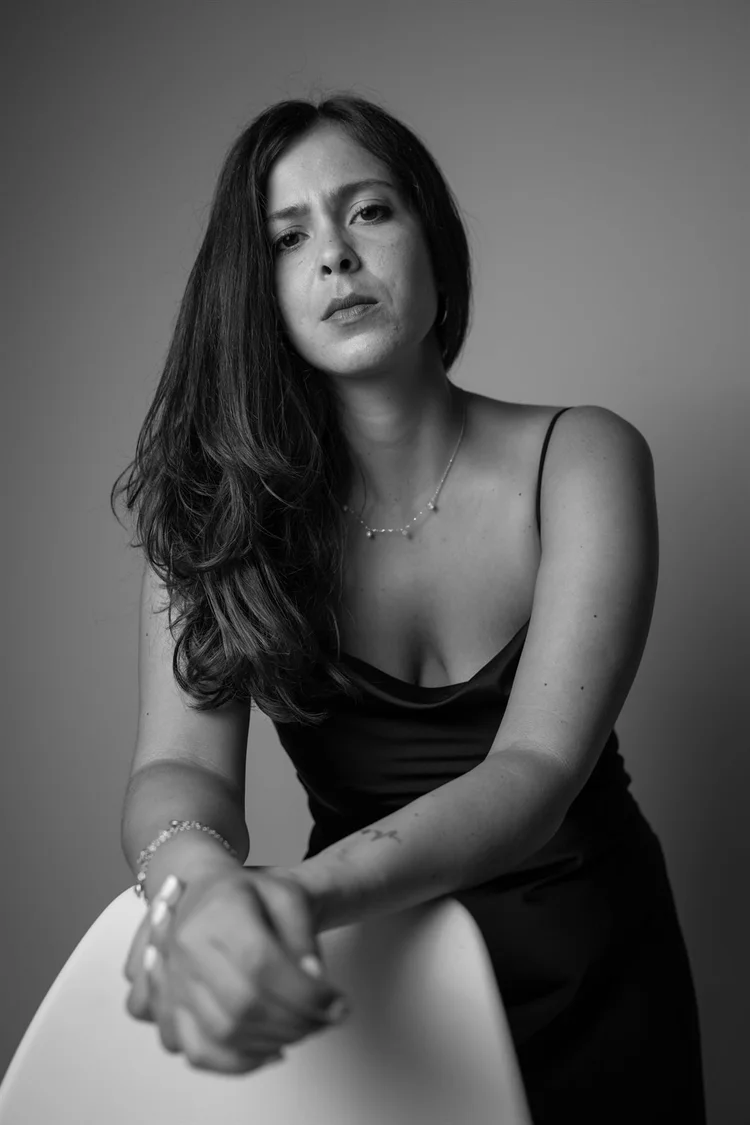 Book attrice in bianco e nero seduta su una sedia bianca, foto di Matilde Rindi, fotografa a Prato