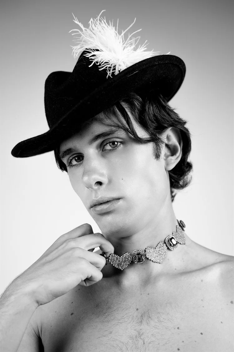Servizio editoriale in bianco e nero: ragazzo con cappello piumato e collare, foto di Matilde Rindi, fotografa a Prato