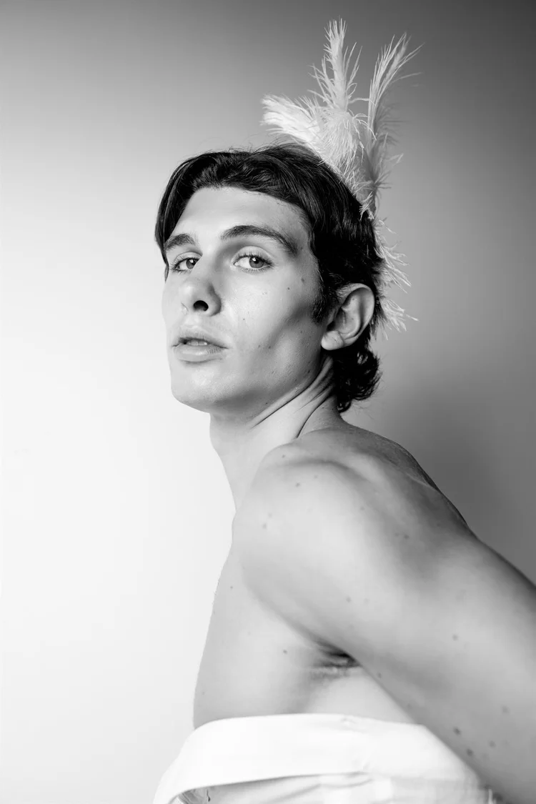 Book per modelli: ragazzo in bianco e nero di profilo con piuma tra i capelli, foto di Matilde Rindi, fotografa a Prato