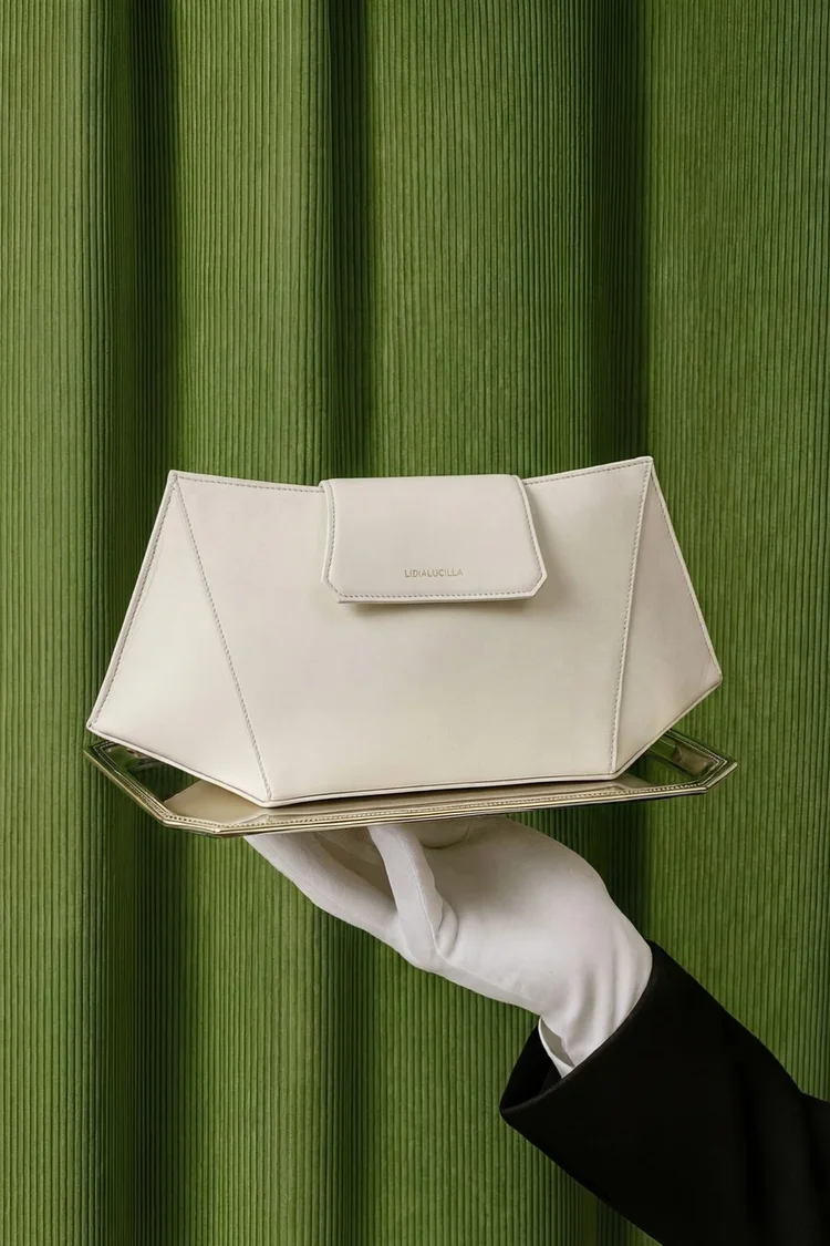 Foto prodotto: borsa bianca su un vassoio, guanto bianco e fondo verde