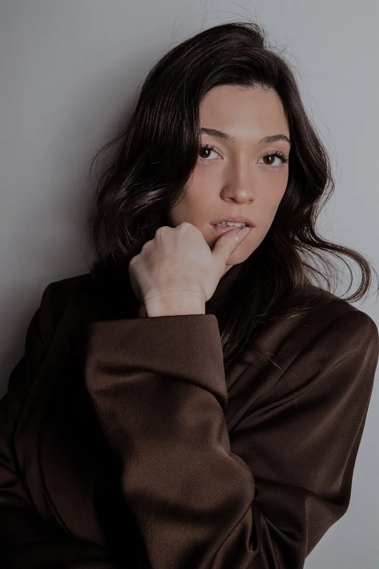 Book attrice con camicia marrone e mano vicino alle labbra, foto di Matilde Rindi, fotografa a Prato