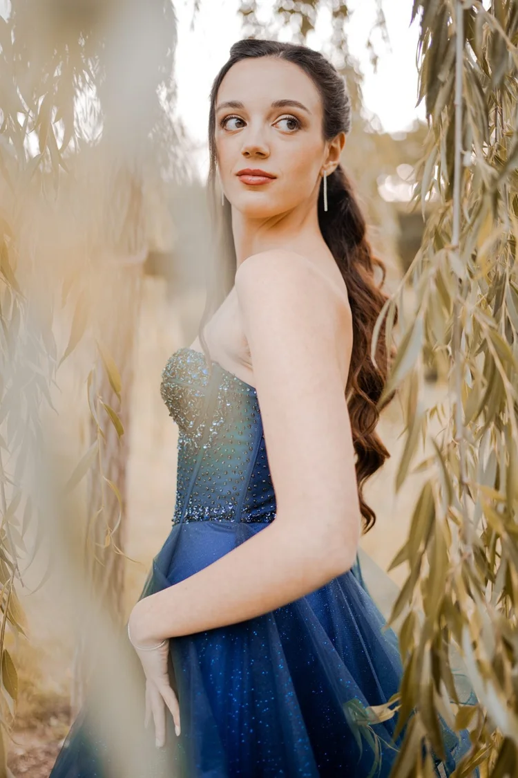 Diciottesimo: ragazza in abito blu tra i rami di un salice, foto di Matilde Rindi, fotografa a Prato