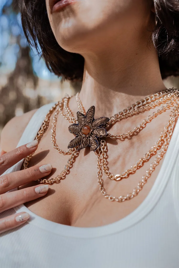 Foto prodotto gioielli: collana dorata con fiore indossata