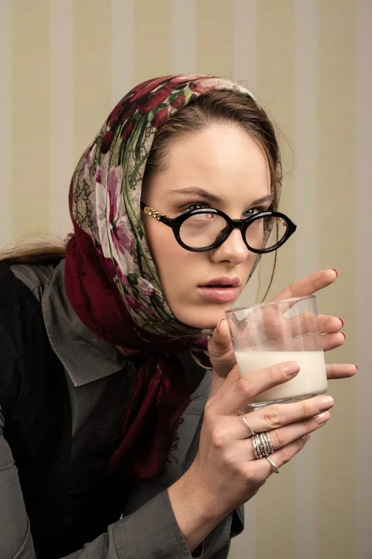 Servizio editoriale: ragazza con foulard, occhiali e un bicchiere di latte