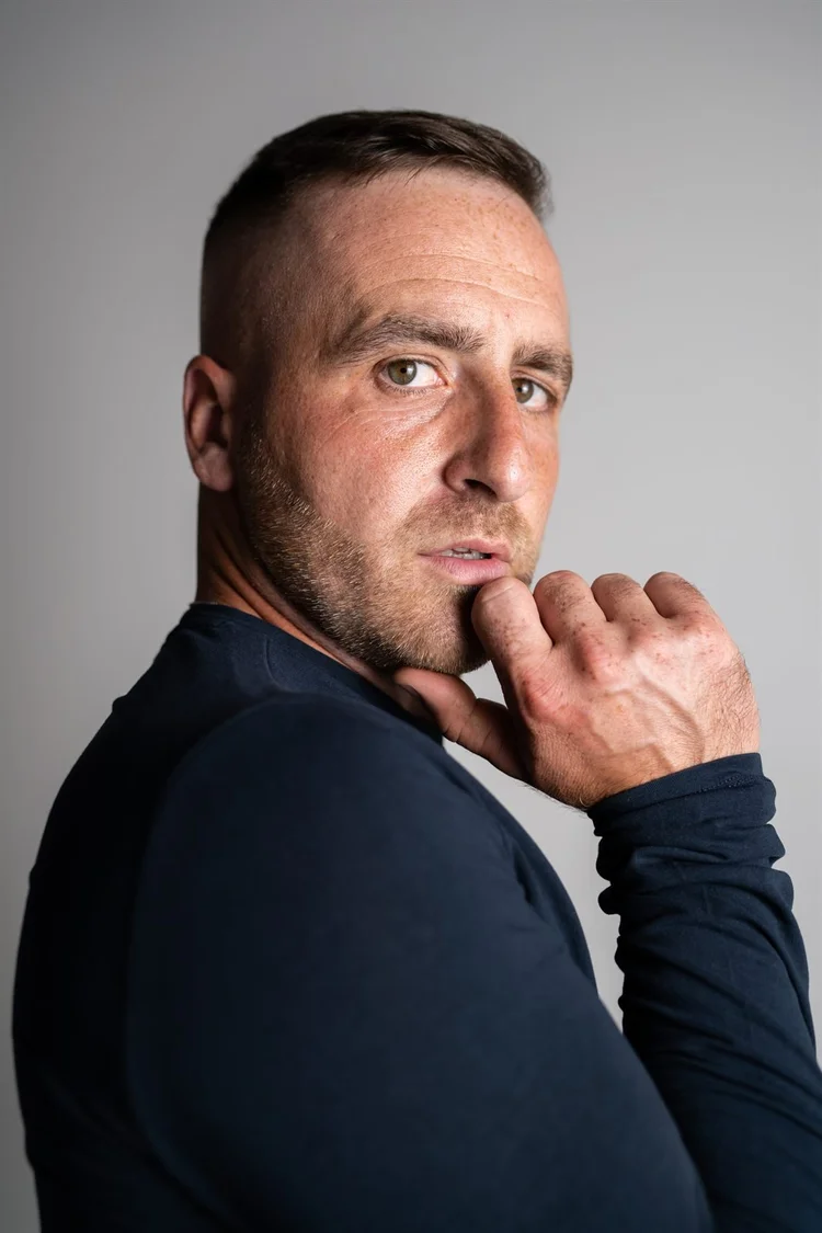 Book attore: ritratto in studio con maglia blu e mano sul mento, foto di Matilde Rindi, fotografa a Prato
