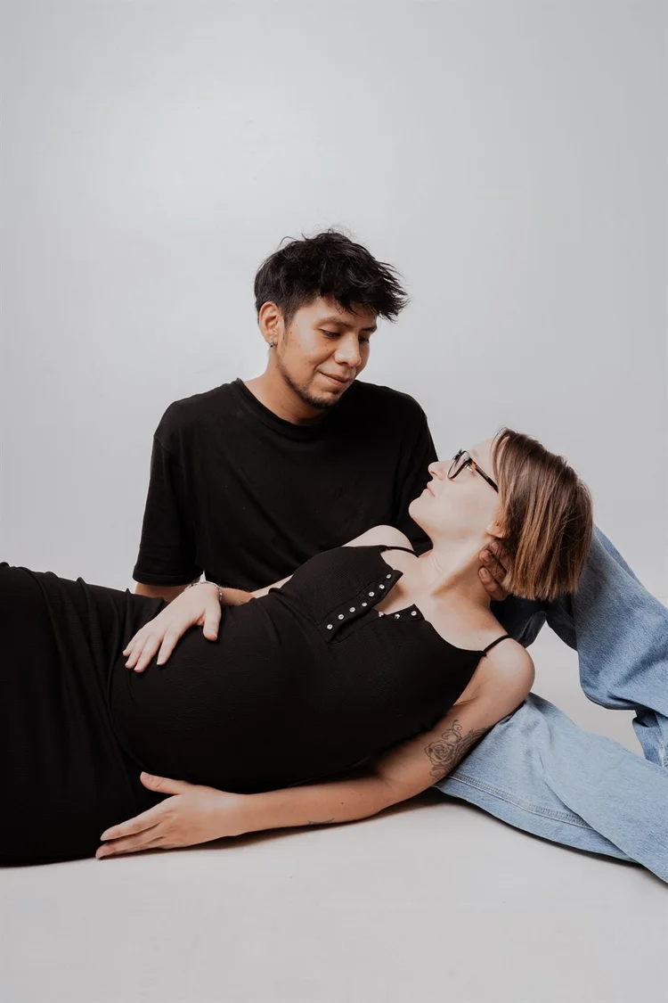 Coppia in attesa in studio, lei sdraiata accanto a lui, foto di Matilde Rindi, fotografa a Prato