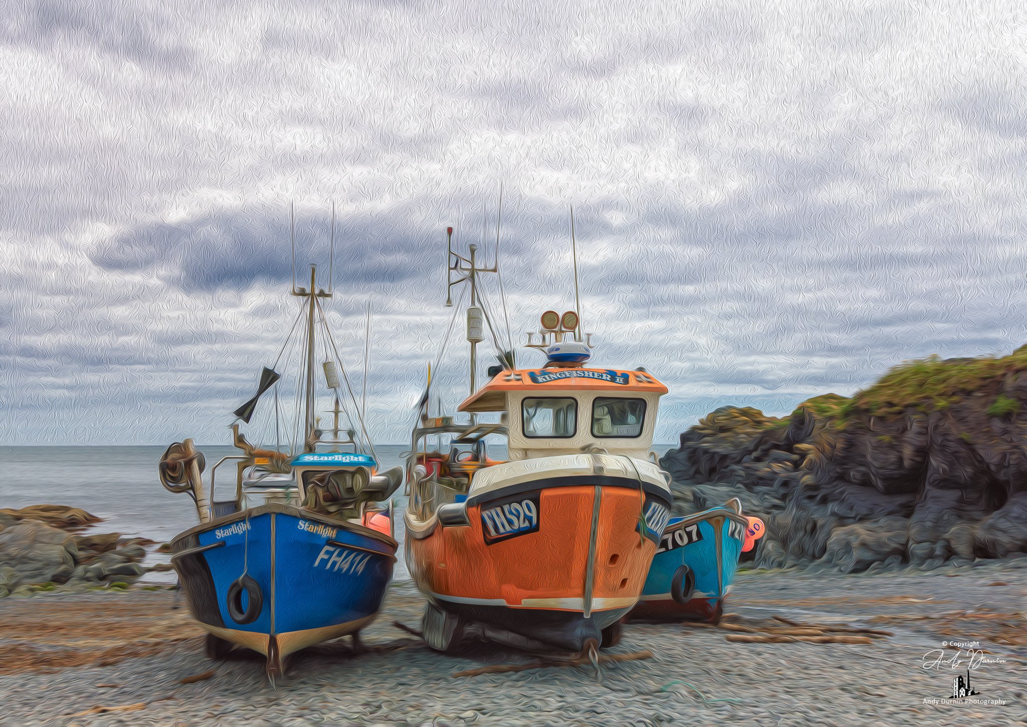 Cadgwith Cove Cornwall  Three boats on a rocky beach under grey cloudy sky, with cliffs in the background