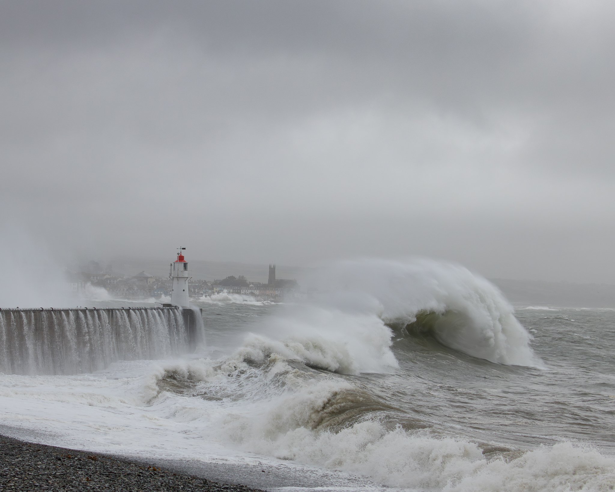 Powerful storm waves breaking against the harbour wall at Newlyn in Penwith, Cornwall.