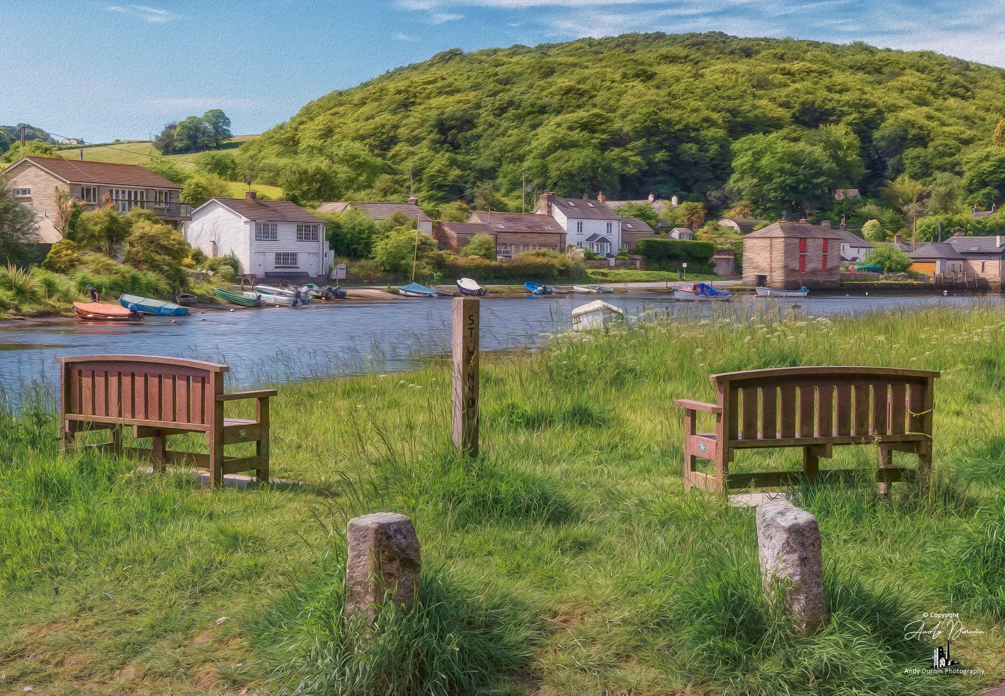 This fine art photograph of the River Lerryn at Lerryn in Cornwall captures a tranquil riverside view with two wooden benches, calm reflective water, moored boats and soft greenery. With a gentle painterly feel, this Cornwall print celebrates the pea