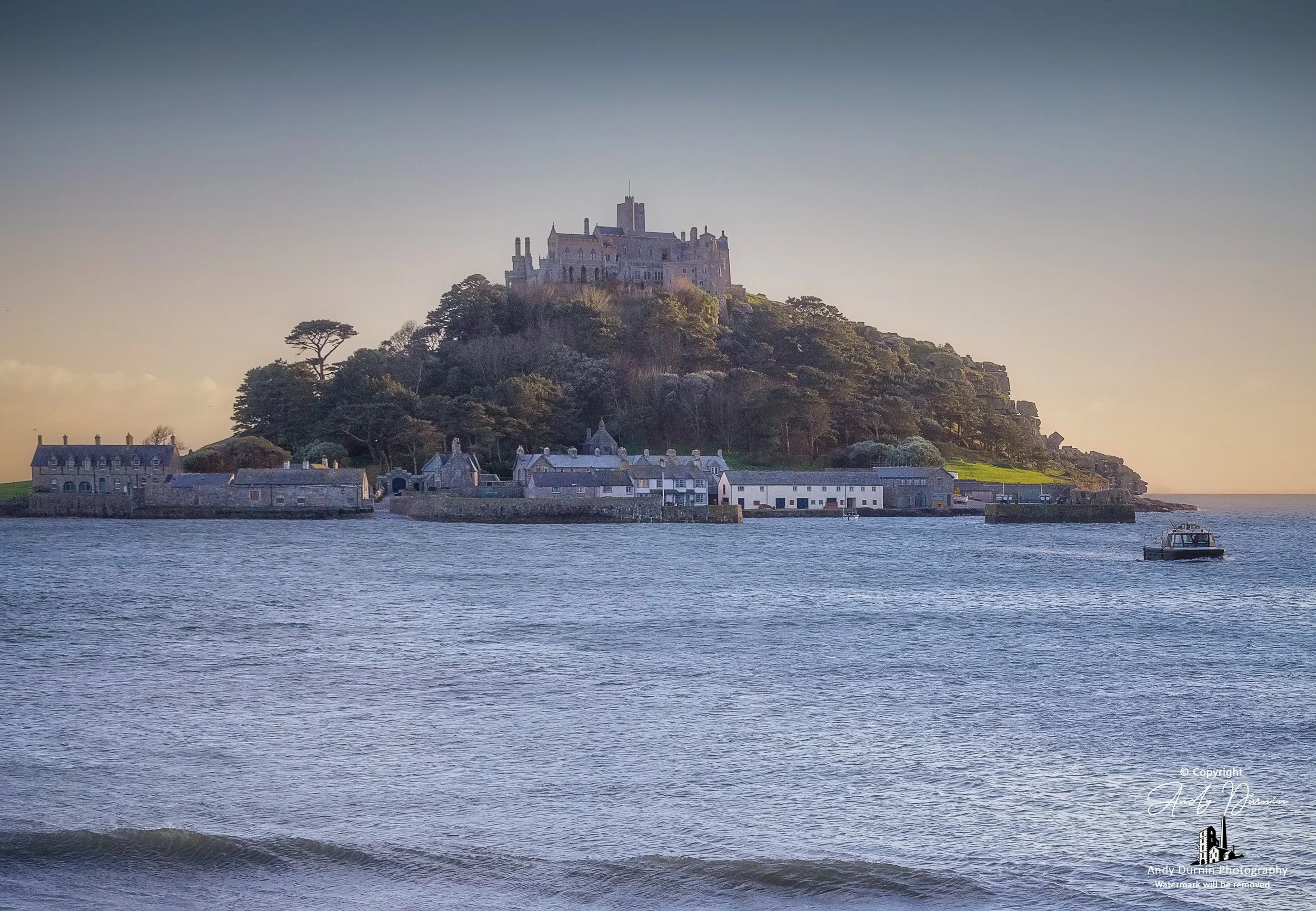 St Michael’s Mount viewed across Mount’s Bay with a water taxi on the sea