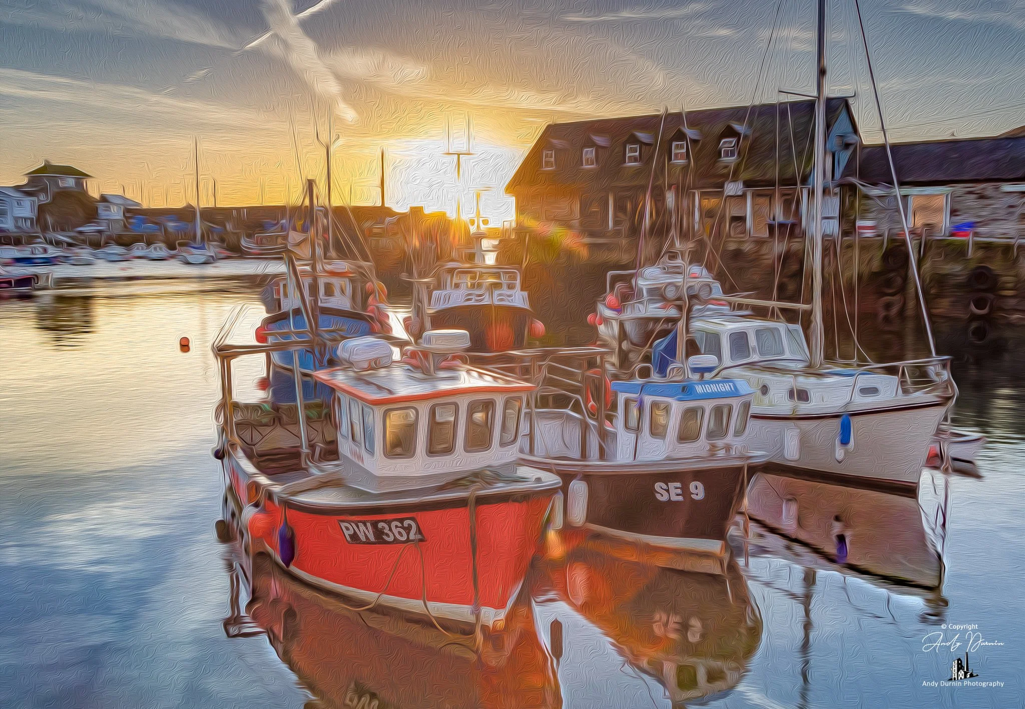 Mevagissey Harbour Fishing boats docked in the harbour during sunset, with colourful reflections on the water.