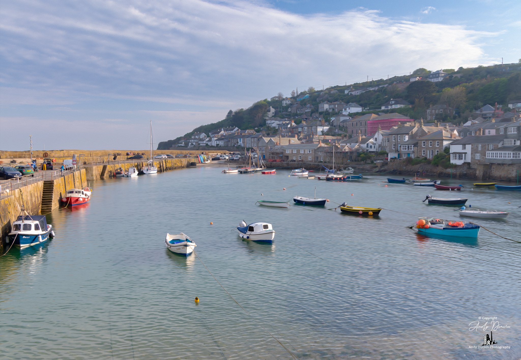This Mousehole Harbour print captures the timeless charm of one of Cornwall’s best-loved fishing villages, with moored boats, calm water, the old stone quay and traditional cottages rising above the harbour. Finished in a soft painterly fine art styl