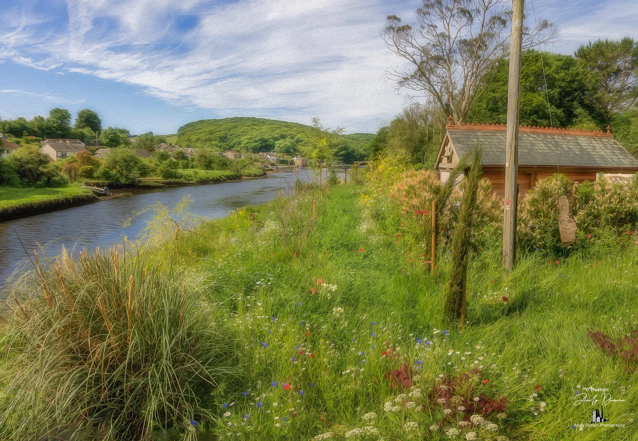 This fine art photograph of the River Lerryn in Cornwall captures a tranquil riverside scene with wildflowers along the river bank, calm reflective water and soft natural detail. With a gentle painterly feel, this Cornwall print celebrates the peacef