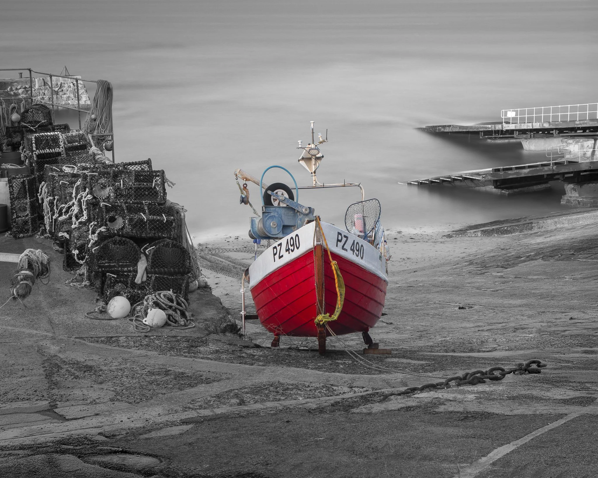 Red fishing boat at Sennen Cove in West Cornwall, captured as a striking coastal photography print.