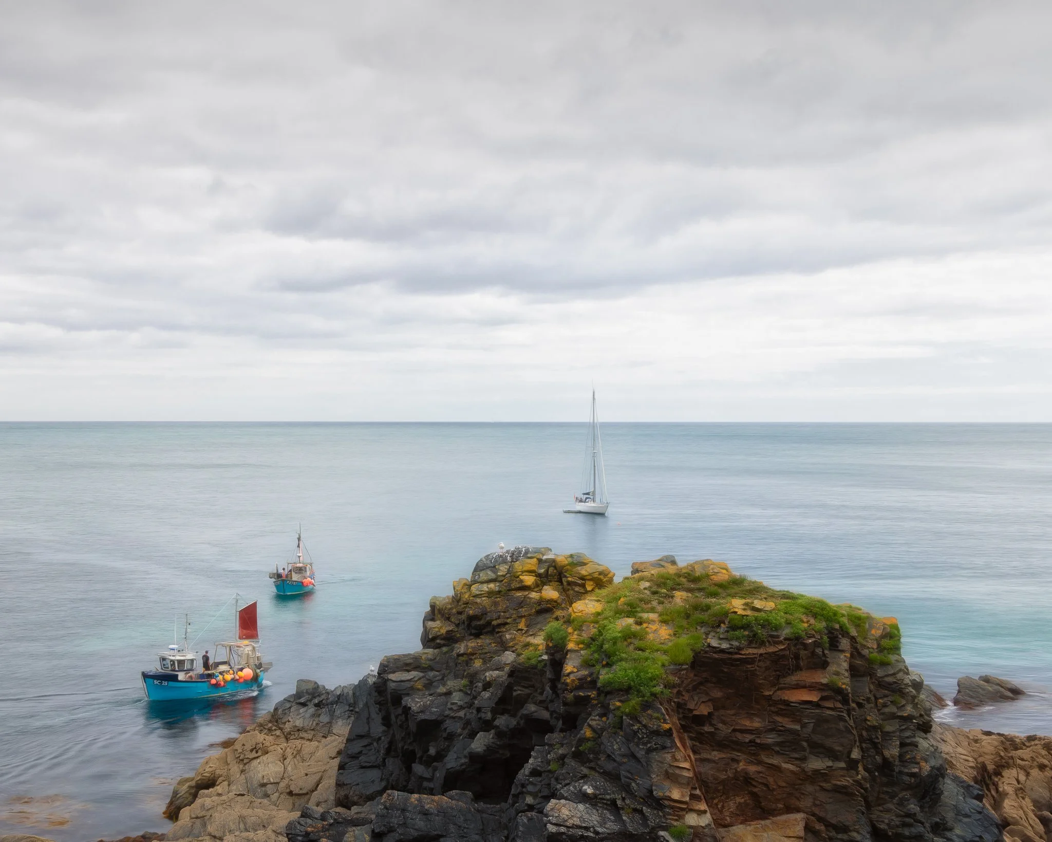Fishing boats resting on the water at Cadgwith Cove on The Lizard Peninsula, Cornwall.