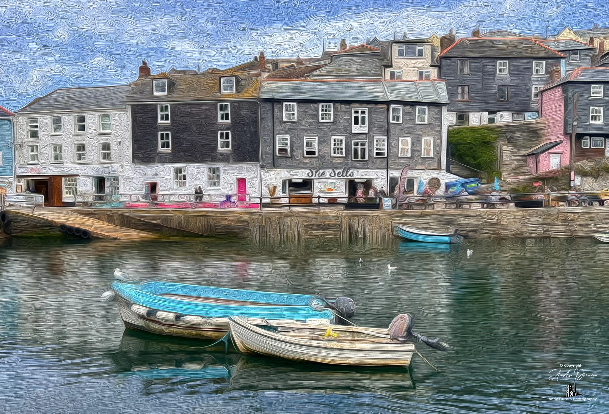 She Sells Mevagissey Harbour.  A harbour scene with three boats floating on water and colourful buildings lining the waterfront with a cloudy sky in the background.