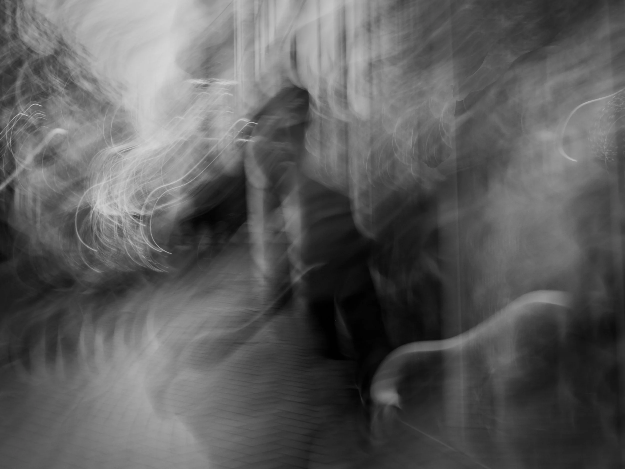 Black and white abstract blurred image with swirling light and shadow patterns