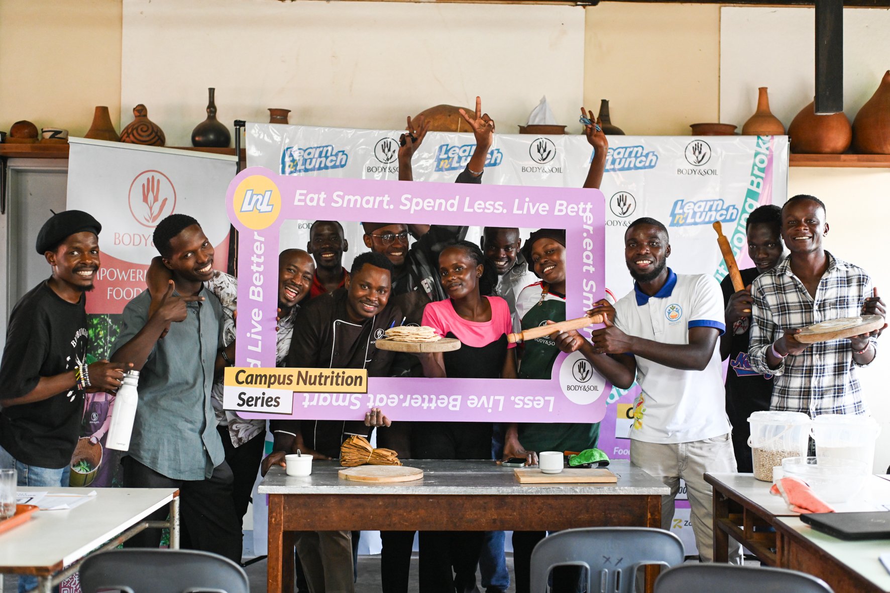 University Students hold up a sigh saying eat smart, spend less, live better