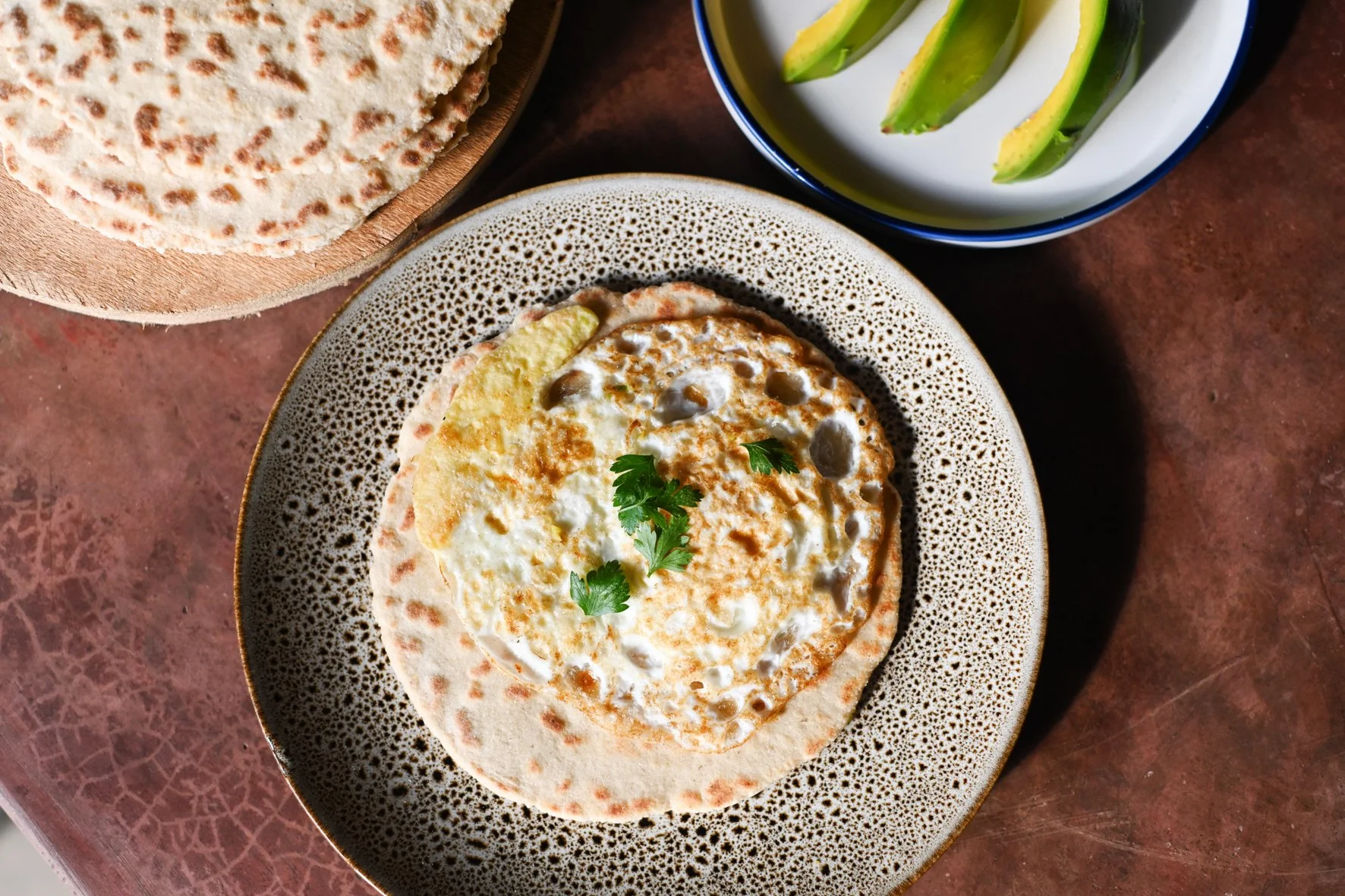 Bean flat bread served with a fried egg and avocado