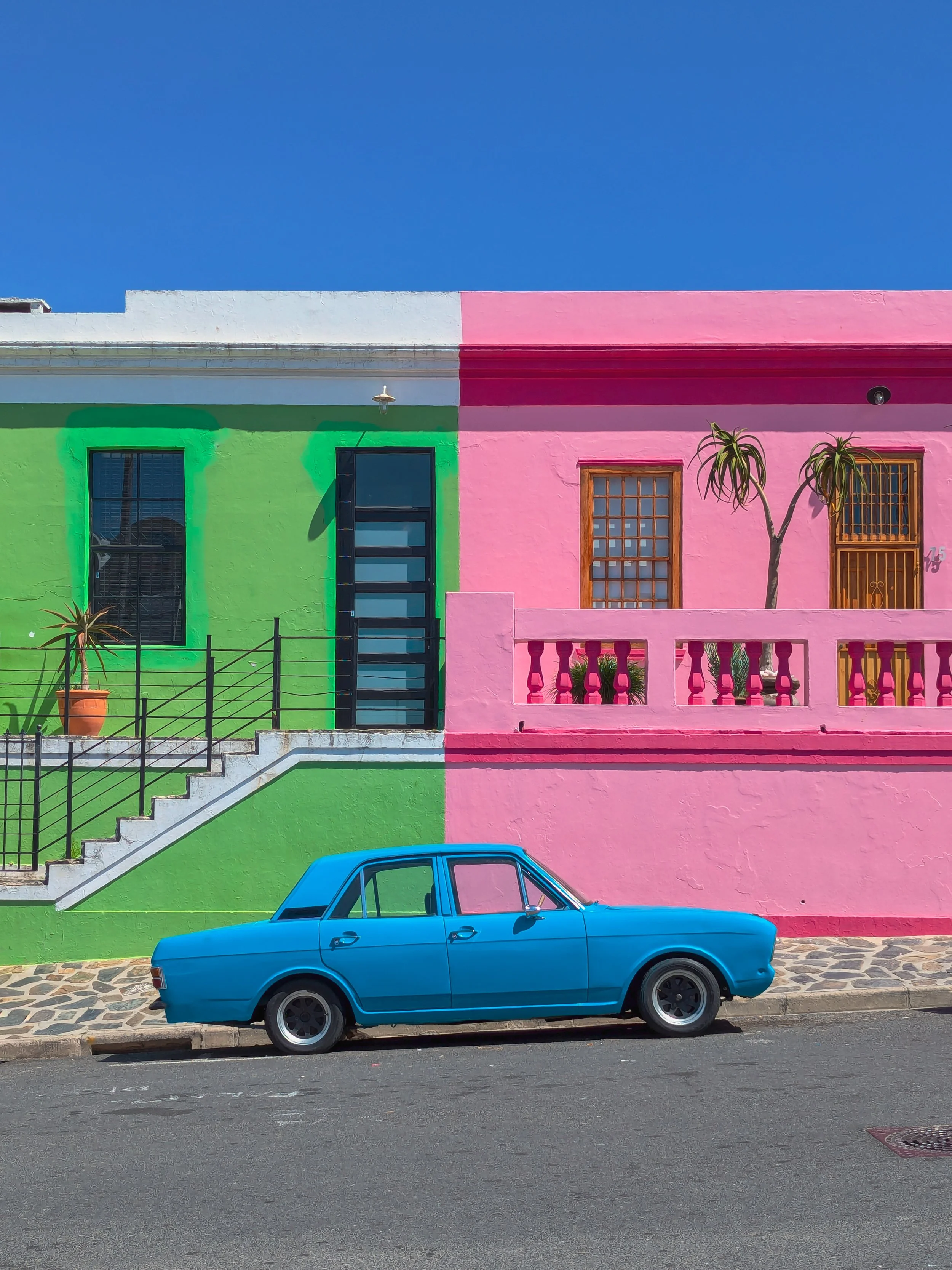 Colour Divides by Robby Ogilvie, winner of the Sony World Photography Awards 2026 Category Object, showing a bright blue vintage car parked between a vivid green and pink house in Bo Kaap, Cape Town under a clear blue sky.