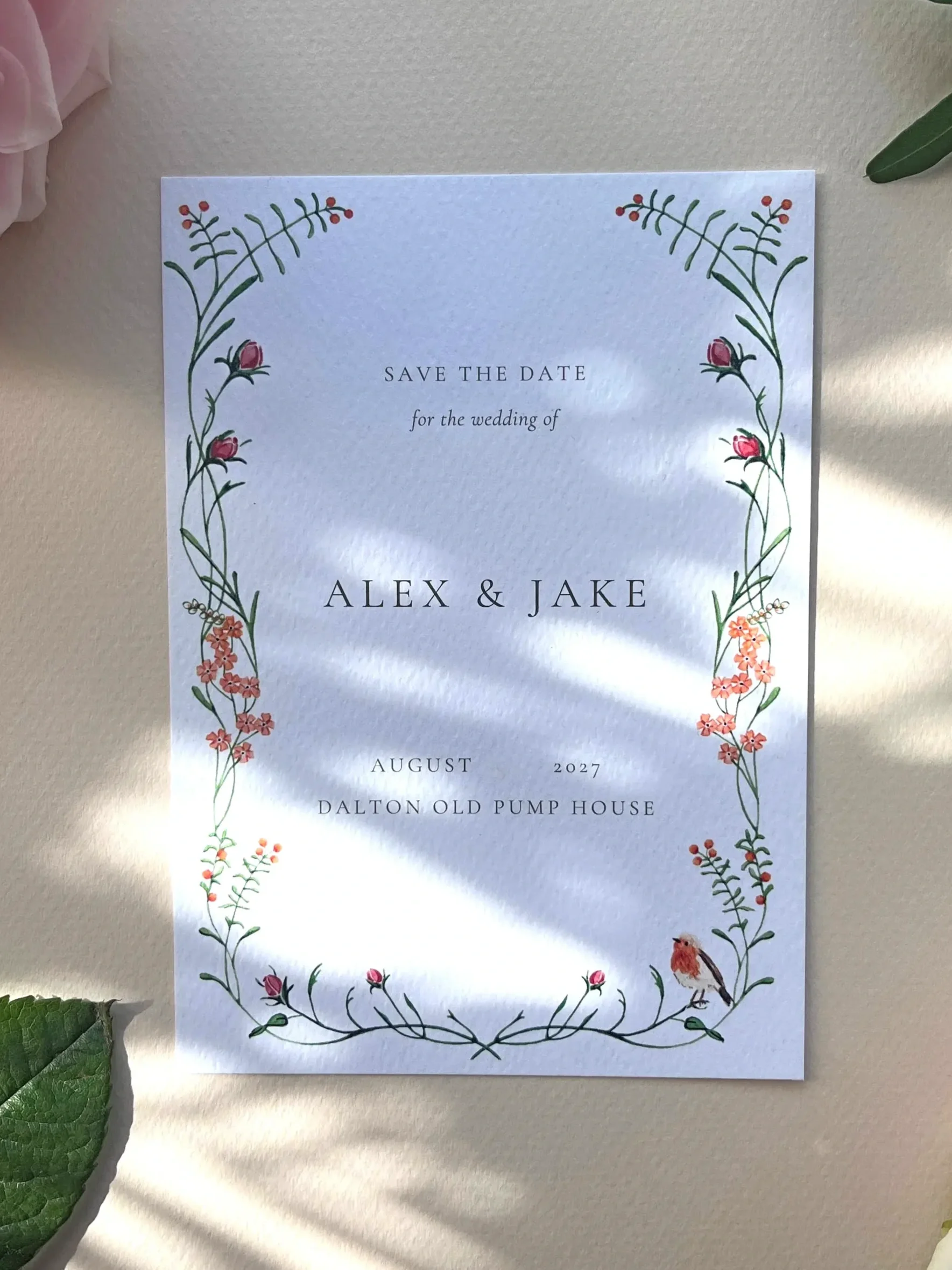 watercolour wedding invitation with foliage flowers and a robin