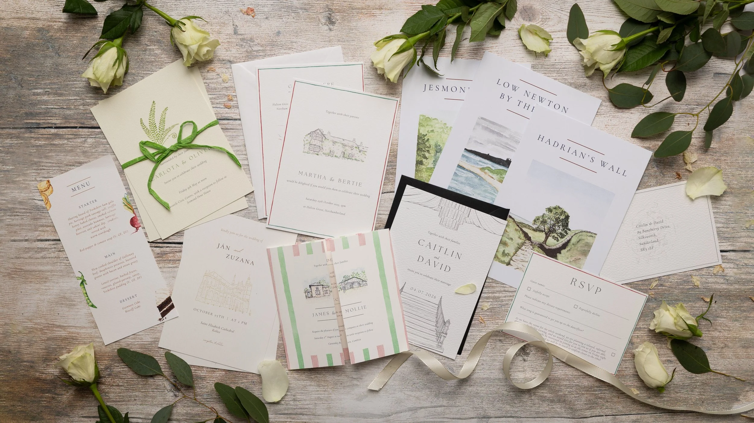 Numerous wedding stationery items on a wooden background with confetti and ribbon