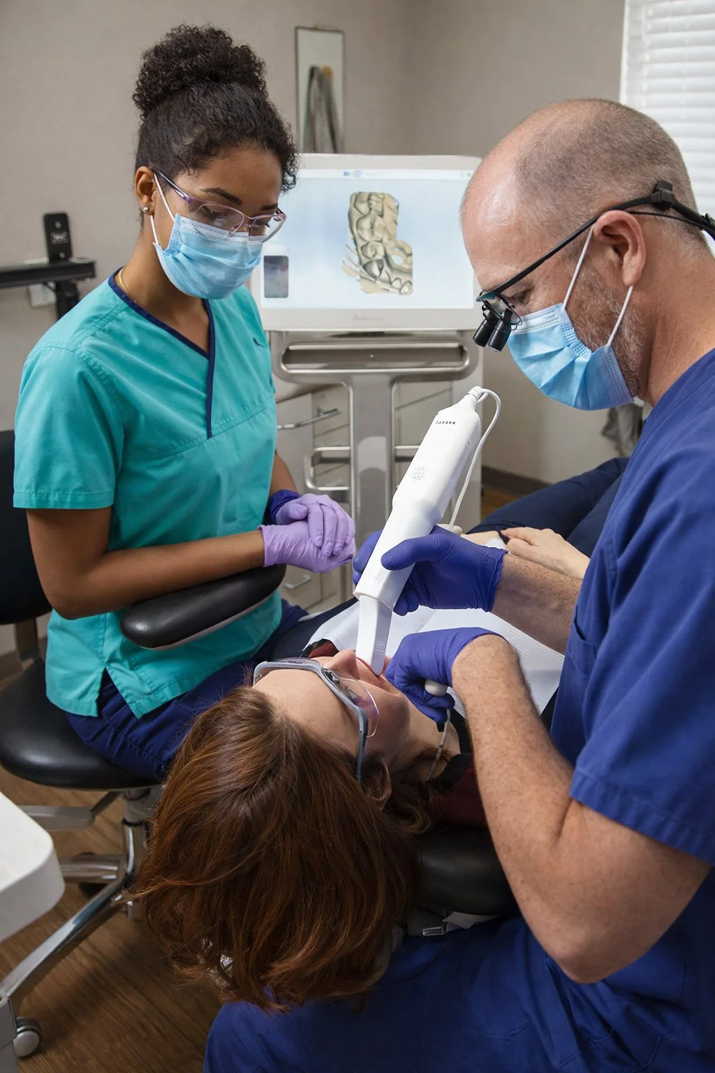 Dentist and dental assistant performing a dental procedure on a patient in a dental clinic.