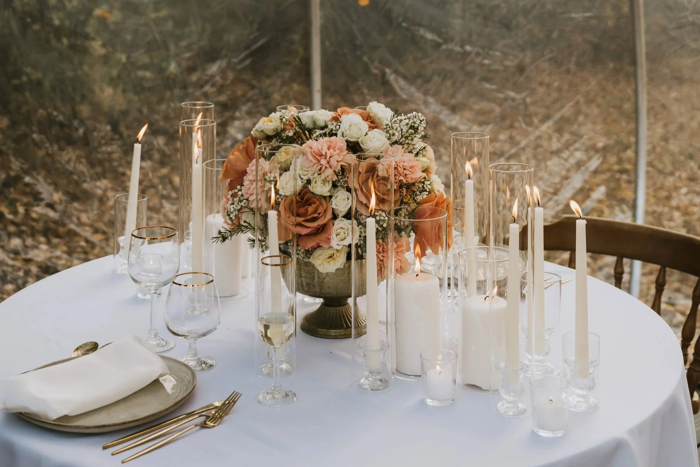 Romantic candlelit table setting for an intimate Alaska elopement, featuring florals and soft neutral tones.