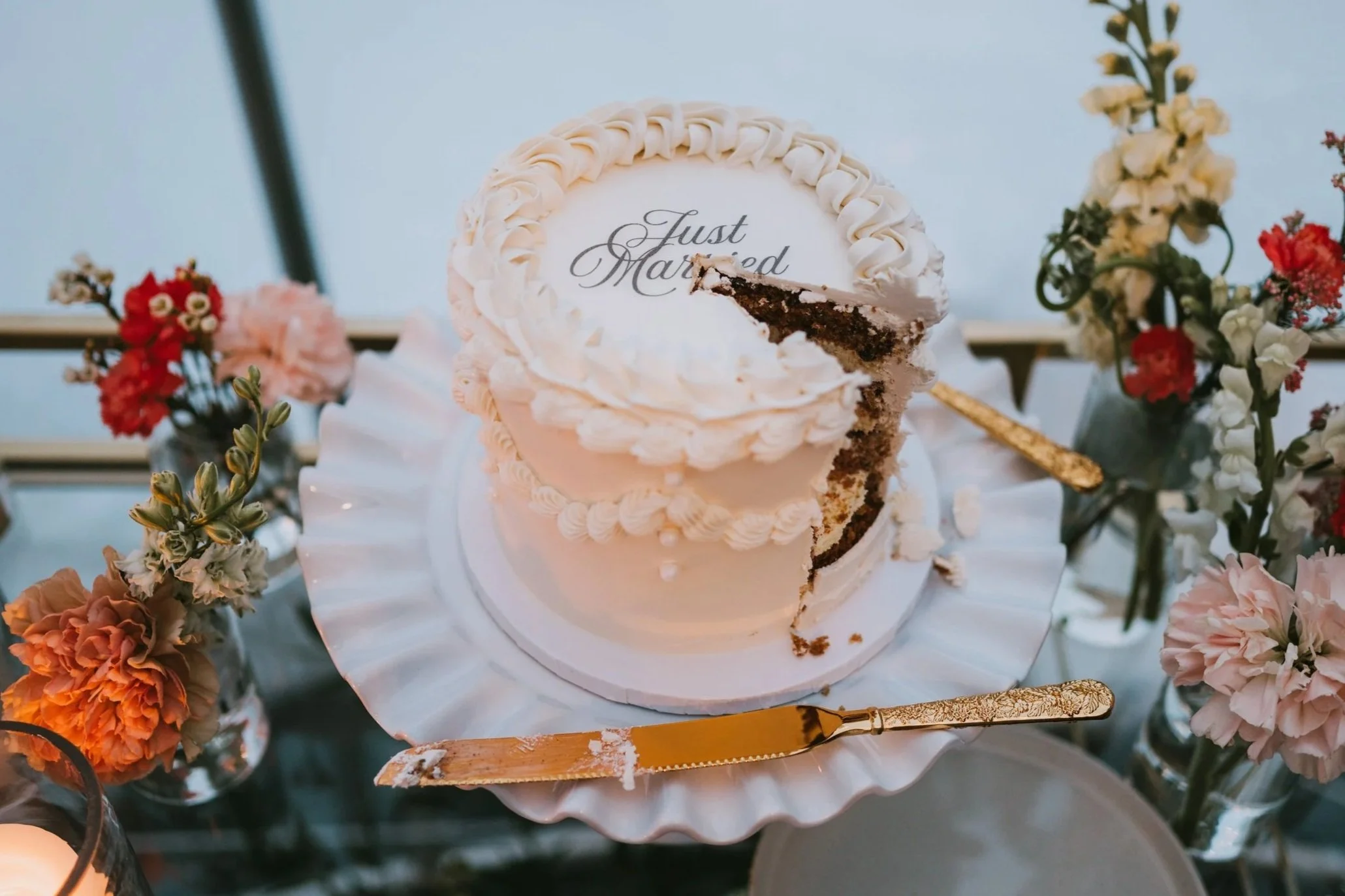 Wedding cake detail for an intimate Alaska elopement, surrounded by soft florals and elegant styling.