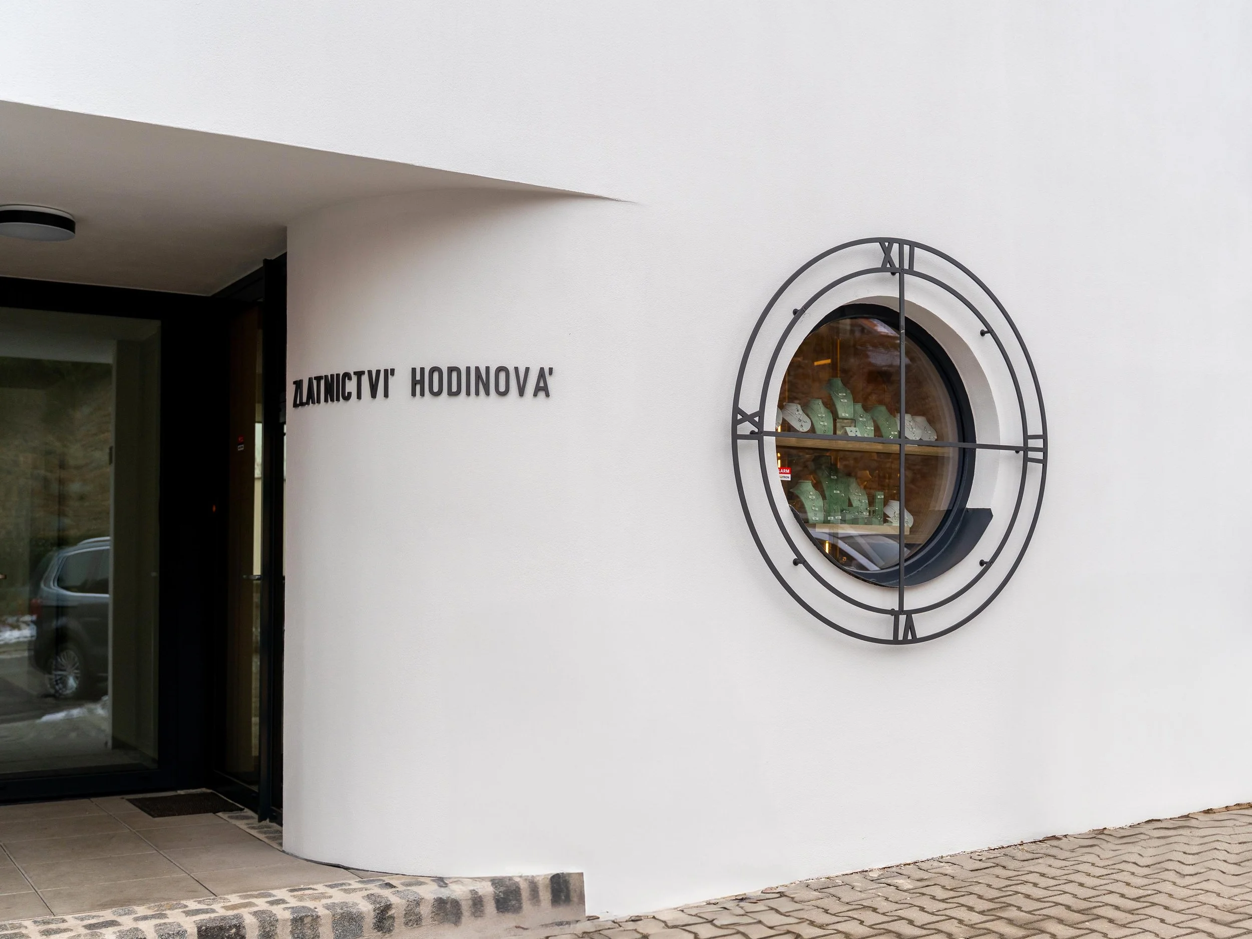 Pohled na výlohu zlatnictví z ulice s vystavenými šperky