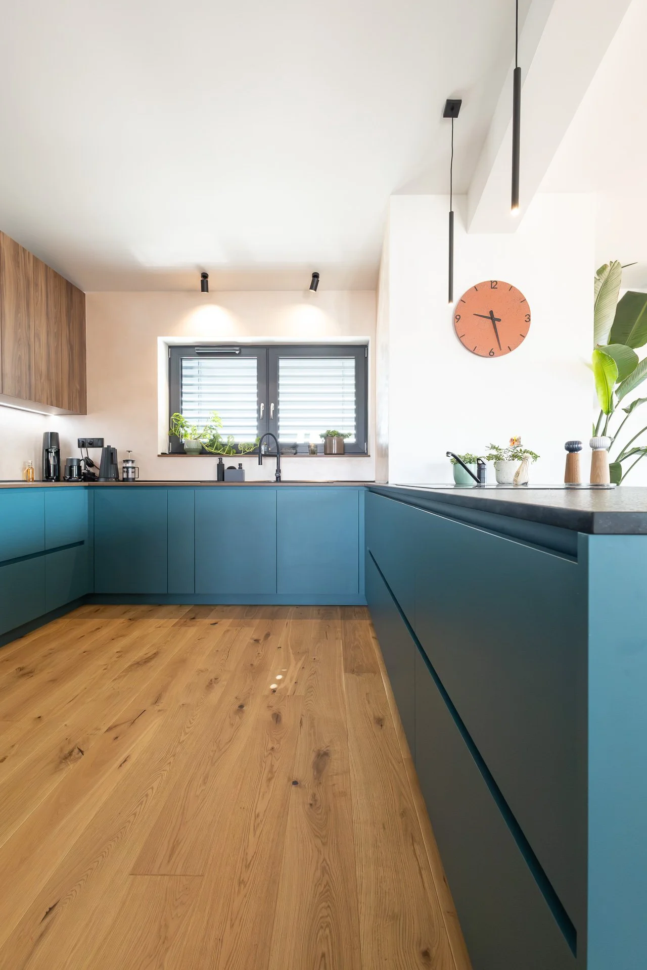 Petrolejová kuchyňská linka s horními skříňkami v tmavém dubu pod šikminou (penthouse Šrámkovka, České Budějovice)
