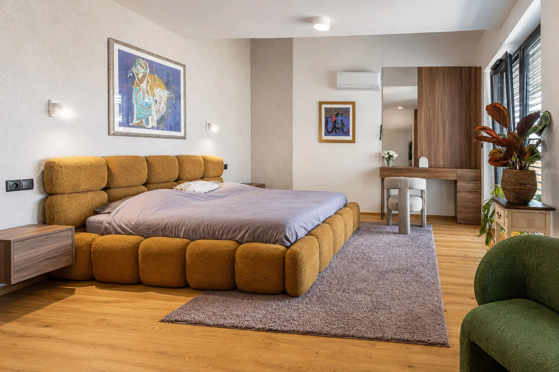 Ložnice s čalouněnou postelí, tapetou a kosmetickým stolkem s obkladem stěny (penthouse Šrámkovka, České Budějovice)