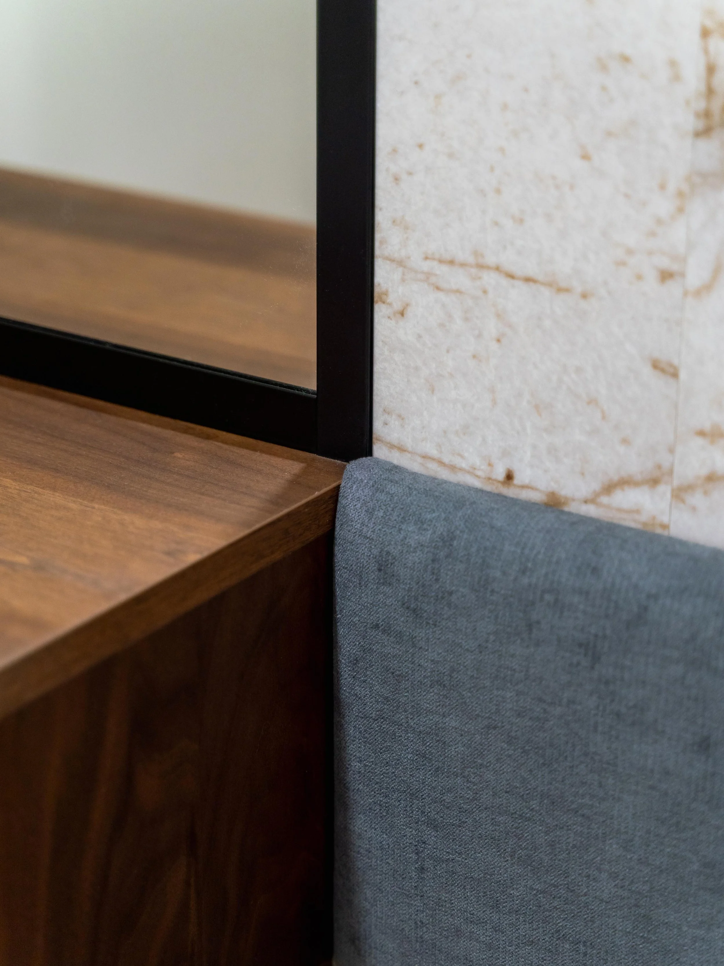 Detail dekorativních kamenných panelů a zaoblených rohů v předsíni rodinného bytu