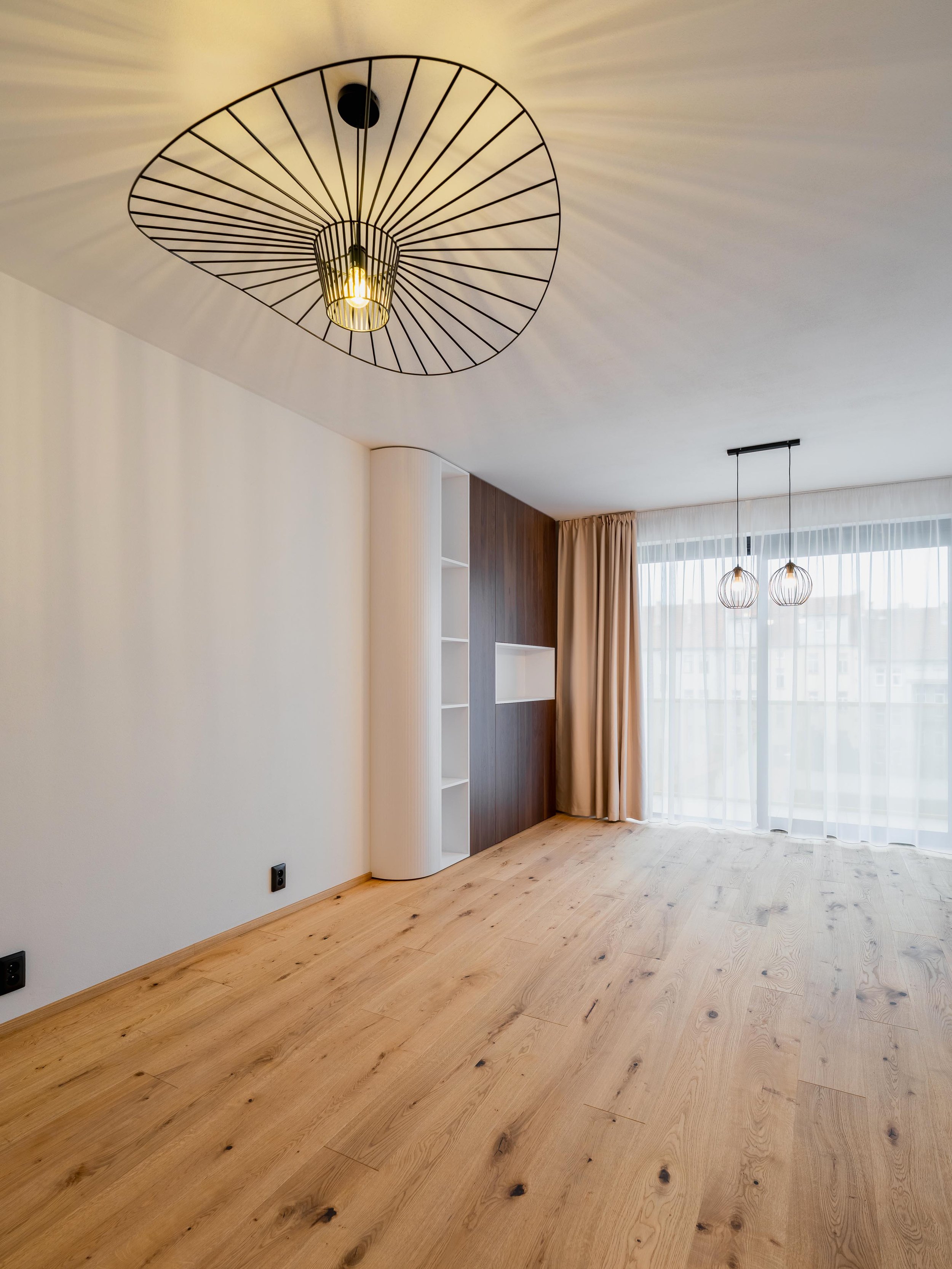 Propojený prostor kuchyně a obývacího pokoje se světlými tóny a nadčasovým designem