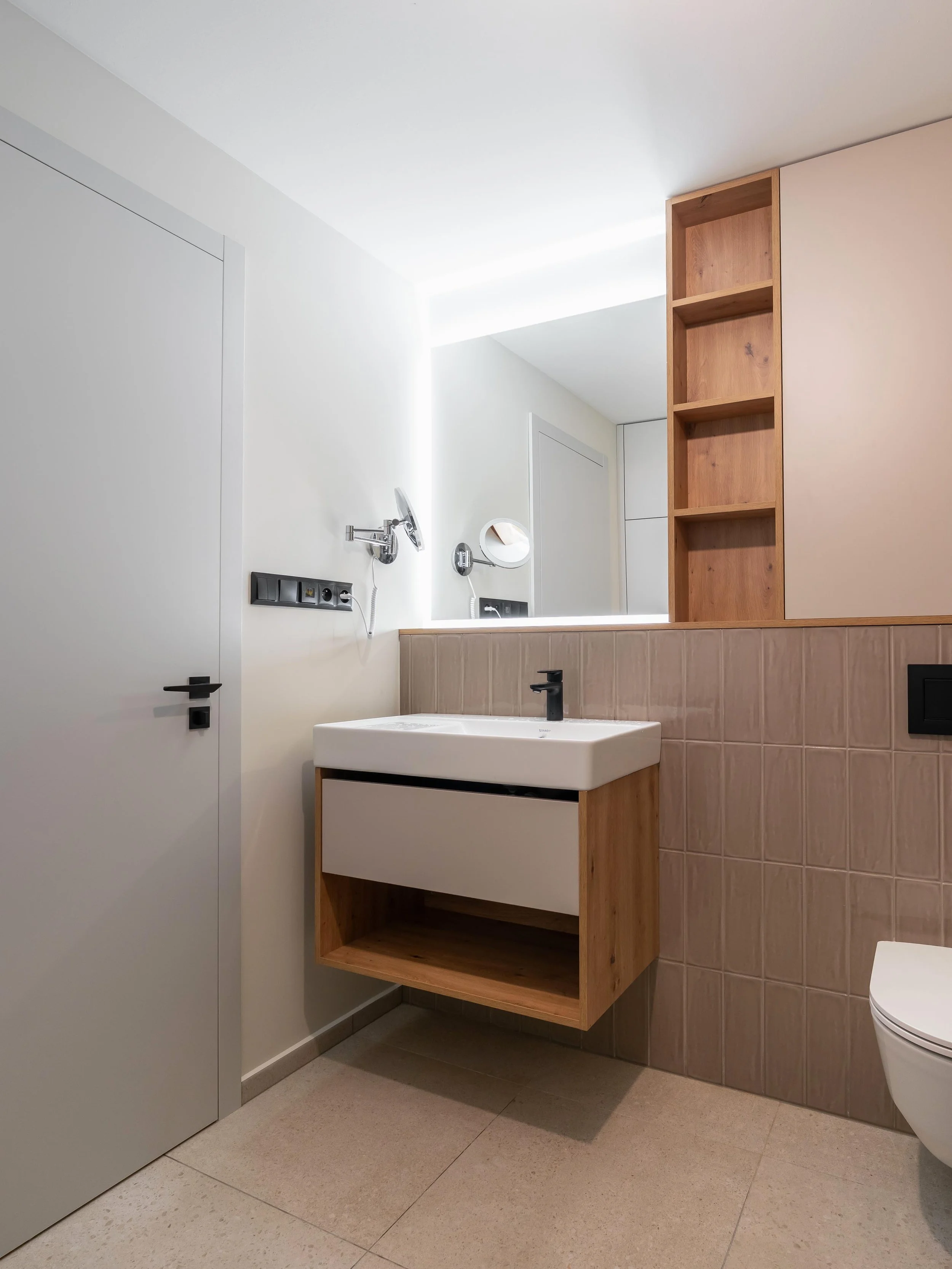 Moderní koupelna garsonky Šrámkovka s praktickým úložným prostorem