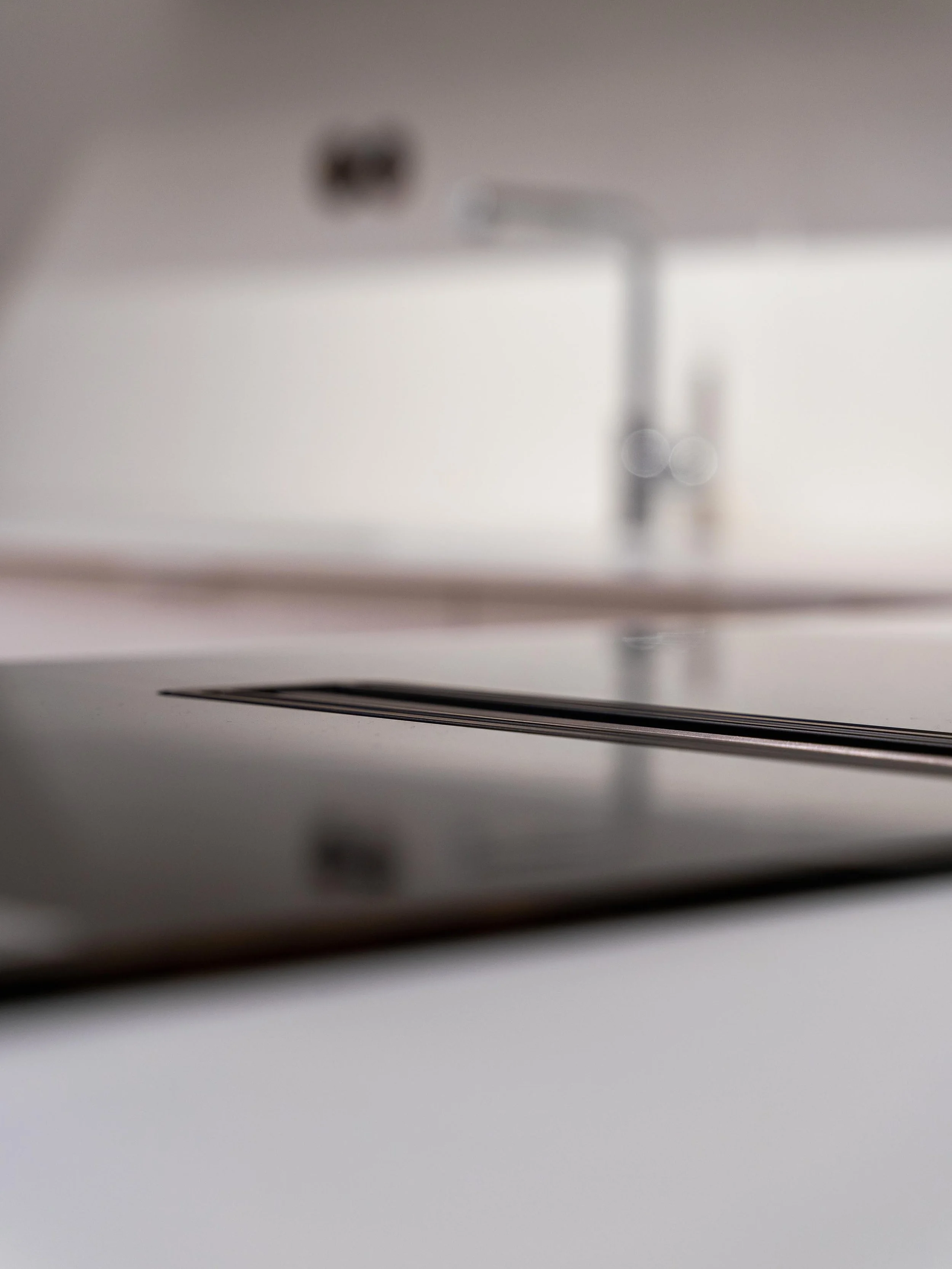 Detail pracovní desky z umělého kamene s varnou deskou a spodním odtahem v moderní kuchyni