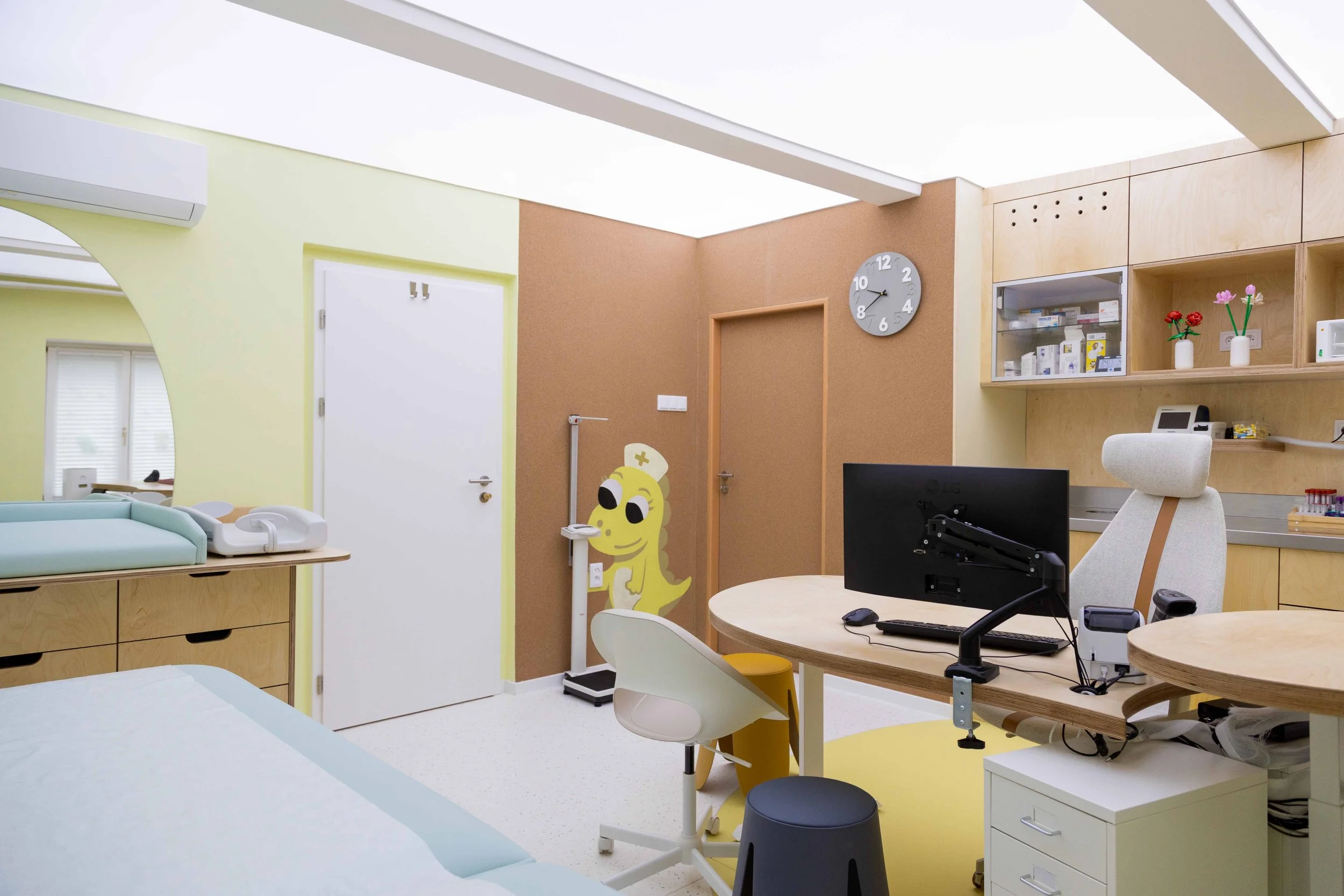 Pohled na lékařské lehátko s čalouněním a úložné prostory v ordinaci