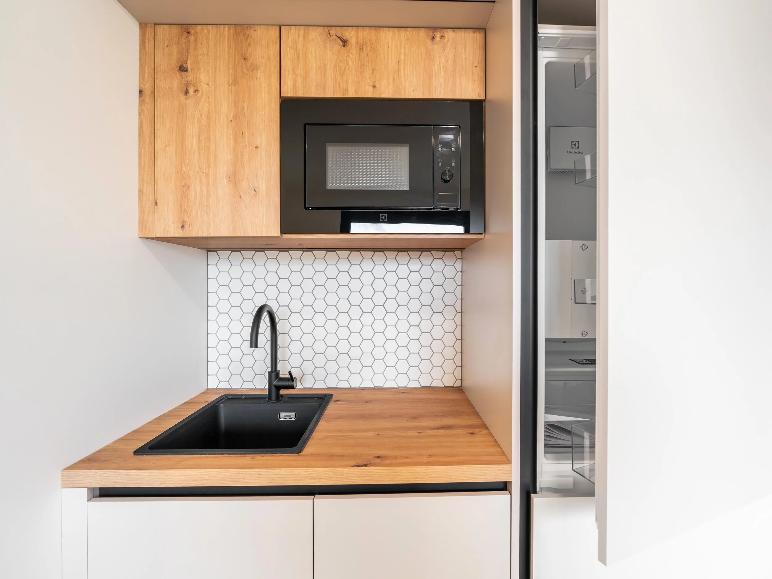 Pohled na kuchyňskou linku s integrovanými spotřebiči a čistým minimalistickým designem