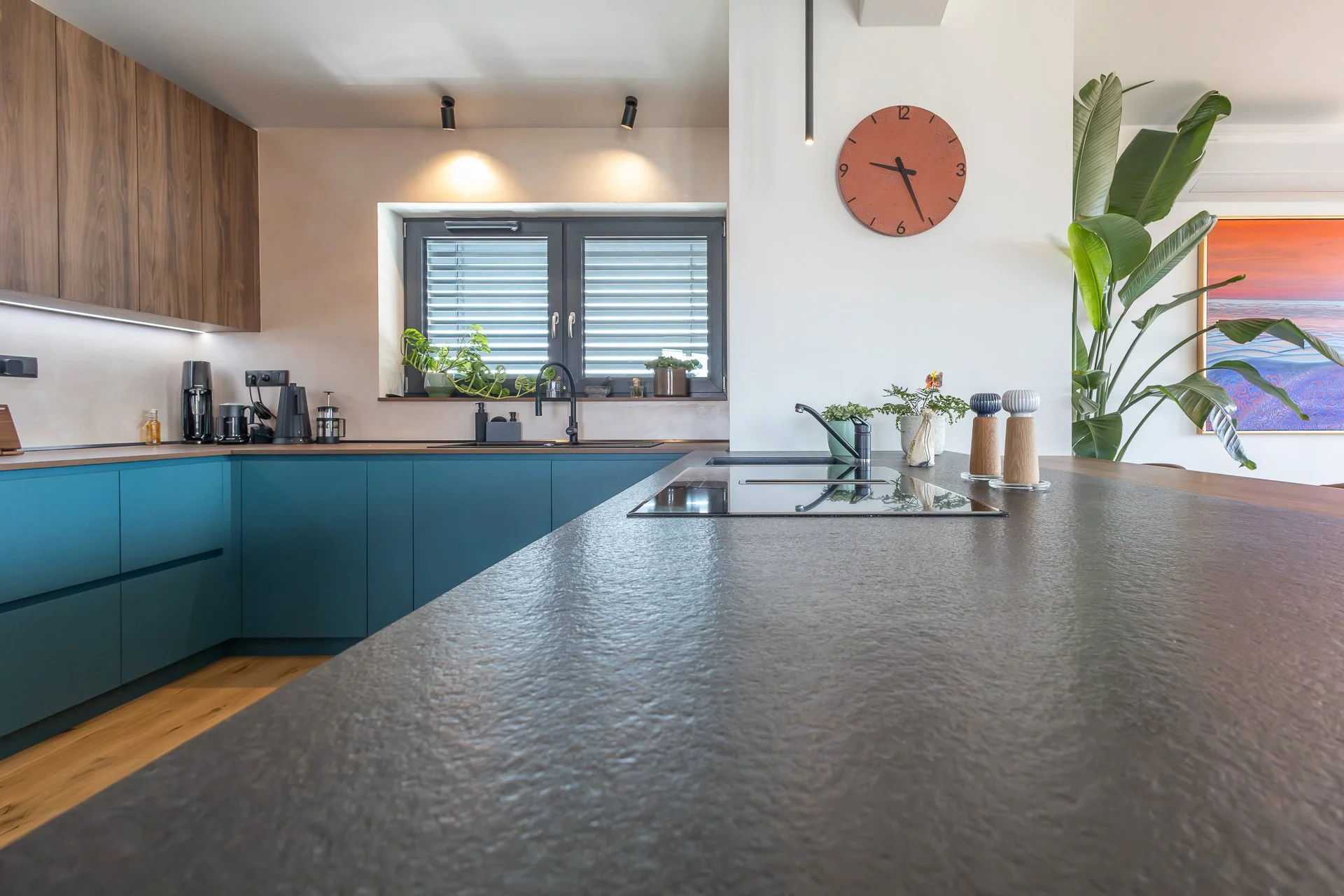 Kuchyně s petrolejovou linkou, ostrůvkem s kamennou deskou a dubovými skříňkami (penthouse Šrámkovka, České Budějovice)