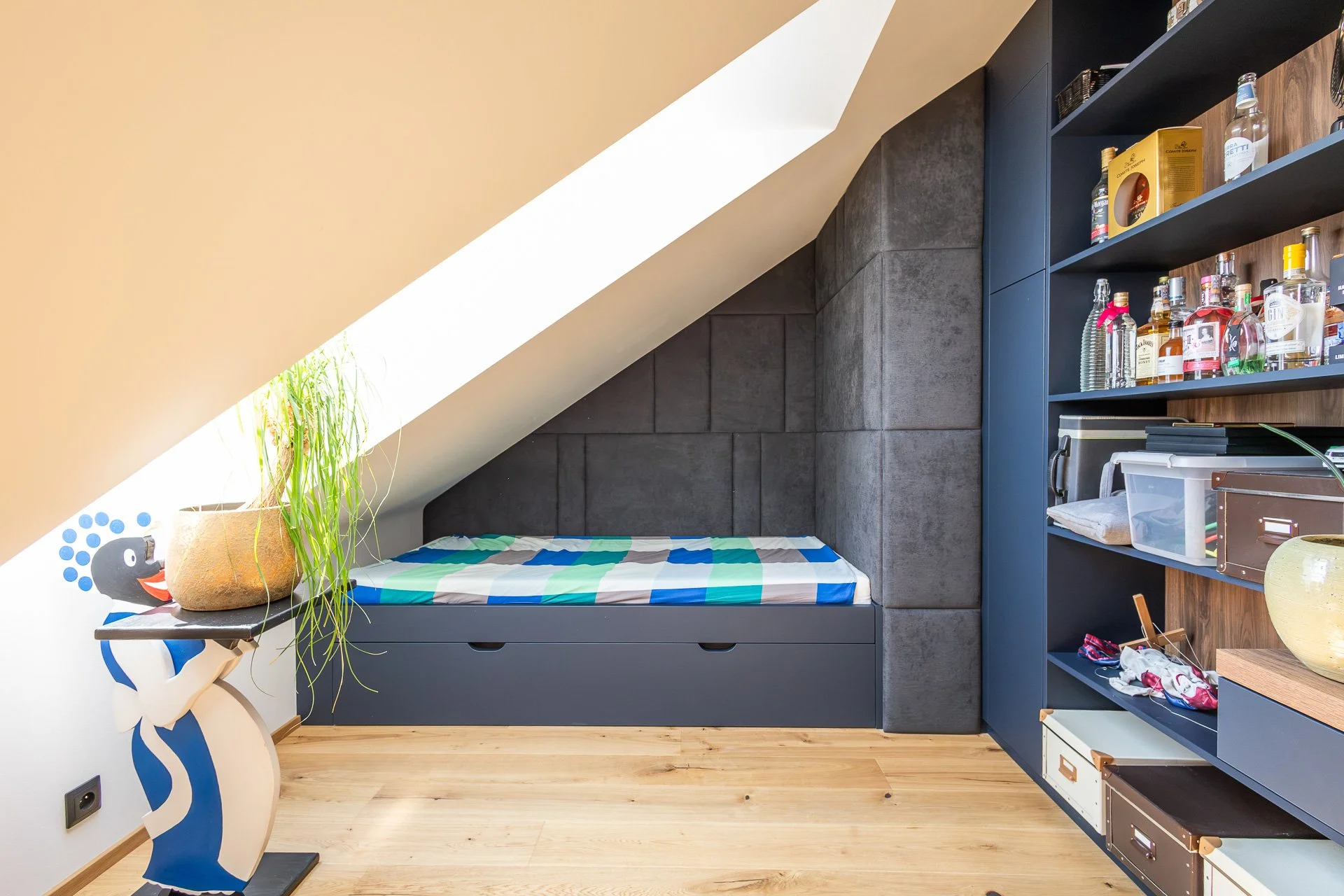 Čalouněné lehátko pod šikminou se střešním oknem v pracovně (penthouse Šrámkovka, České Budějovice)