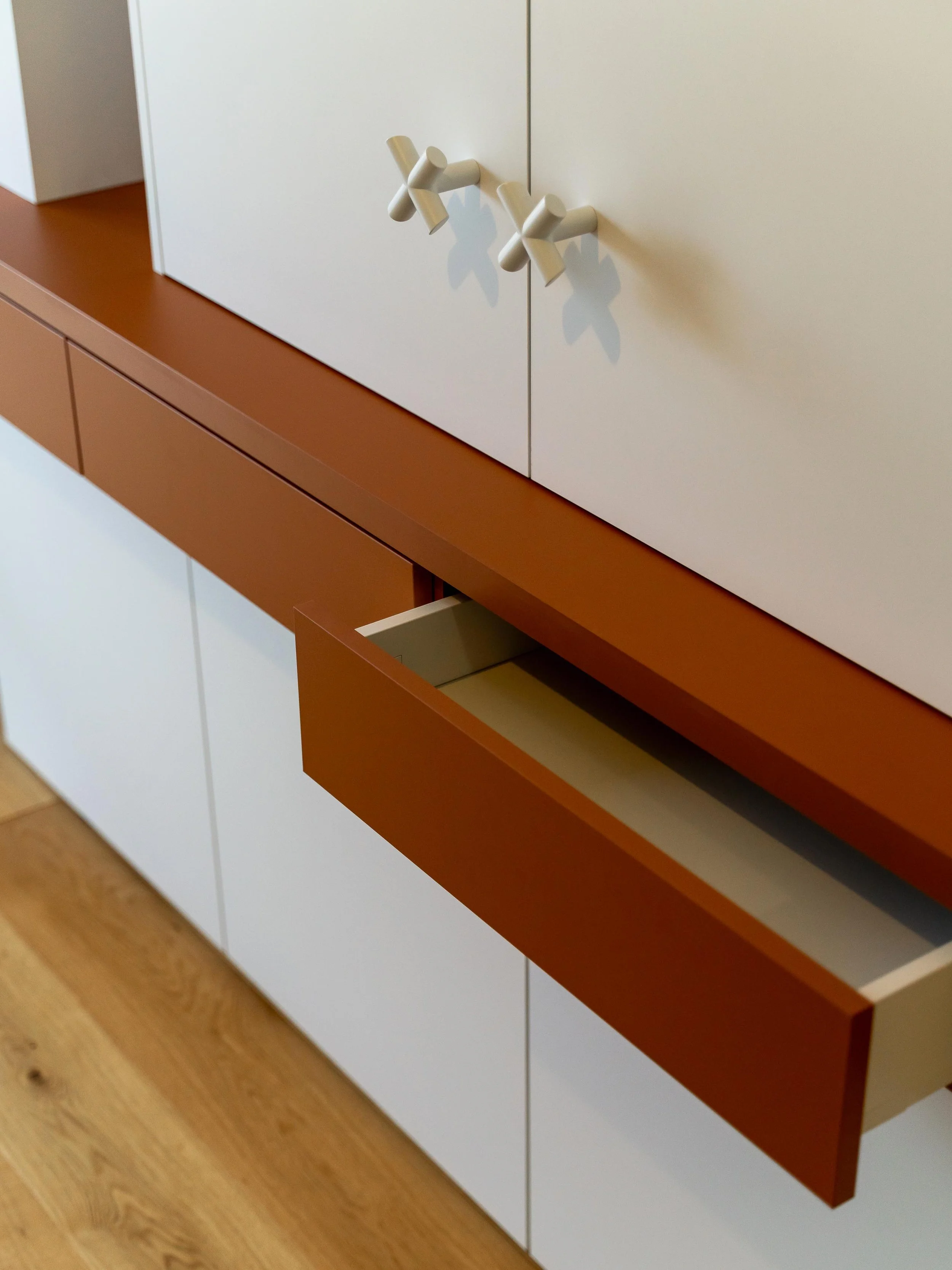 Detail vestavěných skříní v dětském pokoji s bílými povrchy a nadčasovým designem